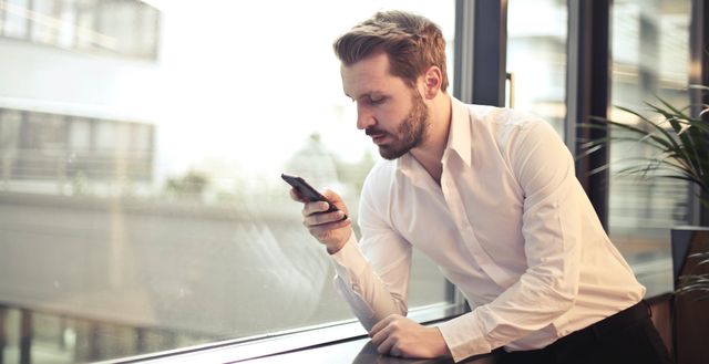 Photo of man reading something on his phone